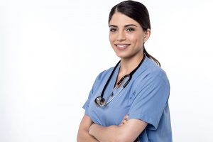 Smiling LPN wearing blue scrubs and a stethoscope.