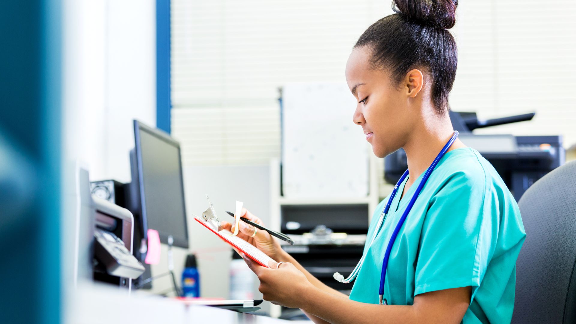 a female nurse looks down at patient paperwork as a part of her skilled nursing career